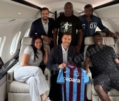 奥纳纳与家人、经纪人在飞机上合影，展示特拉布宗体育球衣